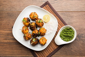 Tandoori aloo are roasted potatoes with Indian spices. It's a party appetiser served with green chutney. selective focus