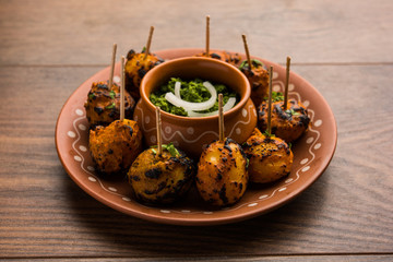 Tandoori aloo are roasted potatoes with Indian spices. It's a party appetiser served with green chutney. selective focus