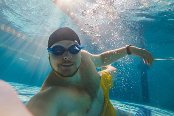 man taking selfie underwater in pool