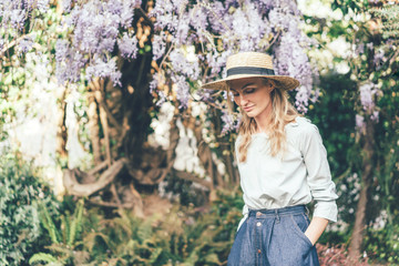 Woman in  boater  hat with wisteria