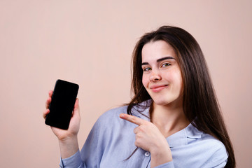 Happy smiling woman with smart phone pointing on blank screen. editable template for advertisement,...