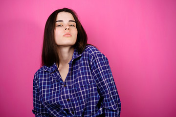 Fototapeta premium Young self-confident woman on a pink background. Femininity, self esteem, people concept