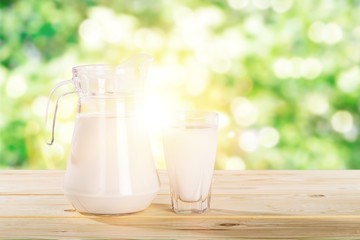 Glass jug of fresh milk  on background