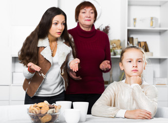 Obraz na płótnie Canvas Upset girl scolded by mother and grandma