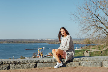 Fototapeta na wymiar Beautiful young girl sitting on the Volga river embankment