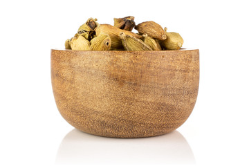 Lot of whole true cardamom pod in a wooden bowl isolated on white background