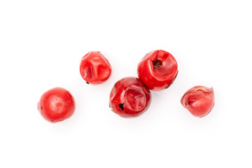 Group of five whole peruvian pink pepper macro flatlay isolated on white background