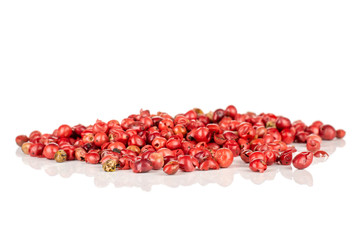 Lot of whole peruvian pink pepper heap isolated on white background