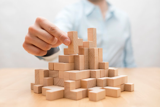 Man's Hand Stacking Wooden Blocks. Business Development Concept 