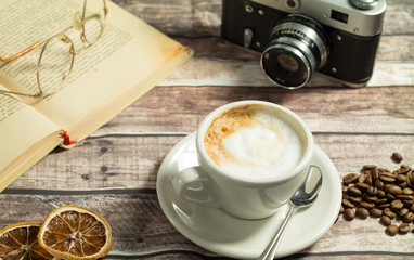 cup of coffee with milk and chocolate cookies on a wooden table