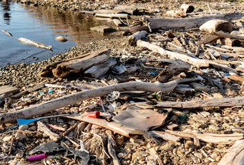 Garbage and trash washed up on a beach after a storm. Plastic debris litters the ground. Concepts of pollution, environment, garbage