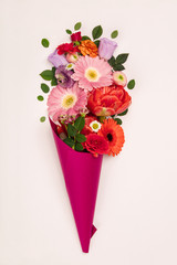 Bouquet of flowers in paper cone on a white background