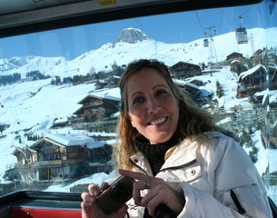 Smiling girl standing cable car snow at sunny day in mountains. Switzerland, Verbier, Alps