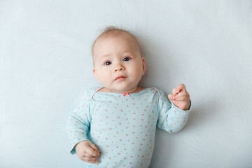 Portrait of a smiling baby in bed. Baby smiling and looking up to camera. Good morning!