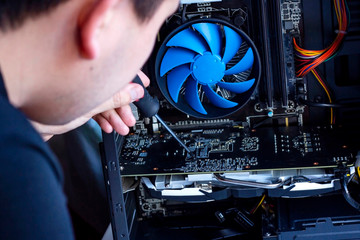 The young technician hold the screwdriver for repairing the computer. Computer hardware, service,...