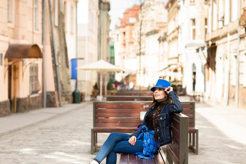 A young woman sits on a bench in the old street, and resting. Lviv, Ukraine