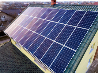 Aerial top view of new modern residential house cottage with blue shiny solar photo voltaic panels...