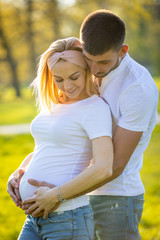 Fototapeta premium Happy couple expecting baby, pregnant woman with husband, young family and new life concept
