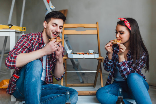 Happy couple doing repairs at home and have romantic time for eating pizza! Lifestyle!