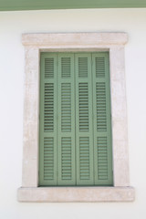 Window with wooden shutters in stone wall 