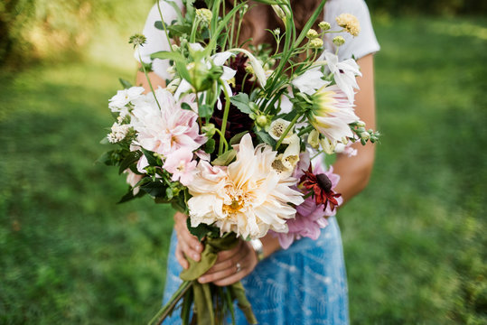 Woman Holding Large Bouquet Of Flowers.