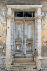 Fototapeta na wymiar shabby wooden door with steps in old stone wall 