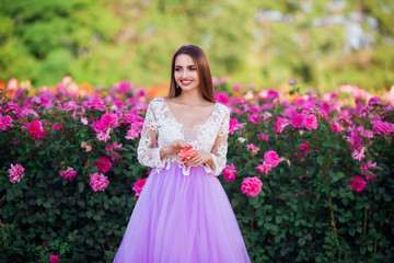 Beautiful girl wearing elegant dress posing near colorful flowers. Art work of romantic woman .