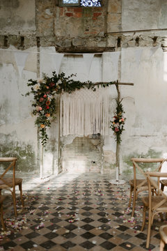 Bohemian handmade macrame backdrop with flowers for wedding ceremony in old abandoned chateau in Normandy