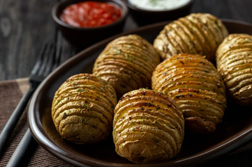 Hasselback potatoes baked with garlic and herbs in oven.