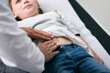 Exam: Doctor Checks Belly Of Young Girl