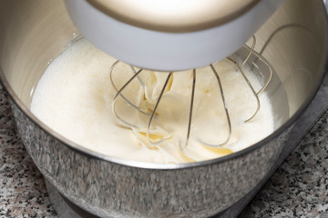 The process of whipping of batter in a planetary mixer. Selective focus.