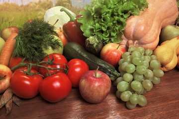 Various fresh vegetables and fruits on a wooden oak table.