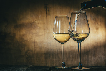 White wine in glasses on rustic background, copy space