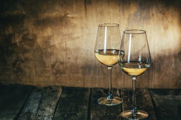 White wine in glasses on rustic background, copy space