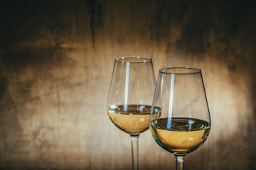 White wine in glasses on rustic background, copy space