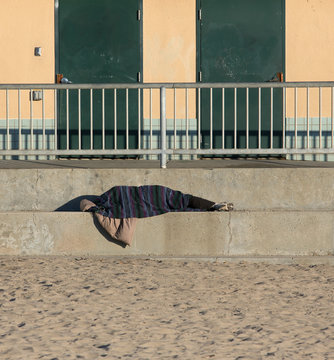 Homeless person sleeping outside at the beach