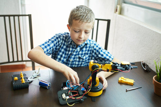 Boy assembling robot arm kit