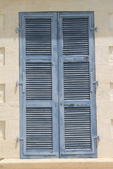 Window with wooden shutters in stone wall 
