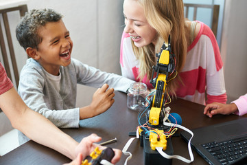 Kids grabbing a girls hair with a robot kit