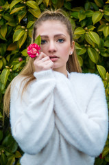 Portrati of a teen girl standing in a bunch of pink flowers, shot shallow depth of field.