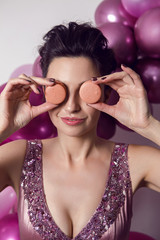 sexy fashion girl in a pink bodysuit standing next to the purple balloons