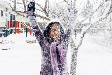 Black girl throwing snow in the air