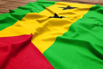 Flag of Sao Tome and Principe on a wooden desk background. Silk Sao Tomean flag top view.