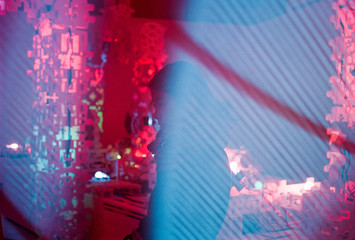 Portrait of woman standing in front of strange red lights covered in blue TV Static