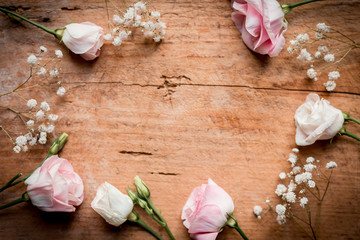 Rosa und weiße Blumen auf Holz liegend