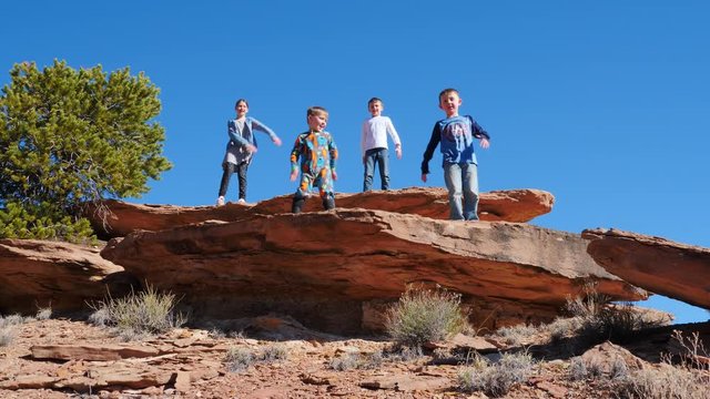 Children doing the floss and dancing on a rock