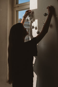Woman decorates wall with disco-ball