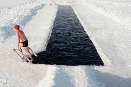Man stepping out of ice-hole
