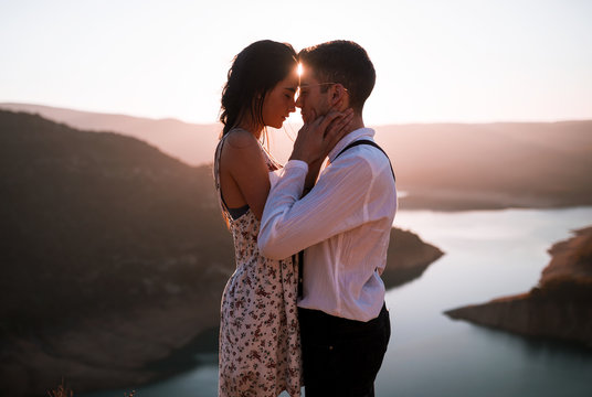 Beautiful young couple in love looking at each other on the mountain.