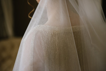 Young woman posing in a white wedding dress close up